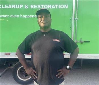 Male standing in front of a green truck.